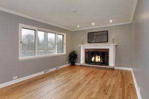 View of spacious room with wood flooring, gray walls, and large gliding windows.