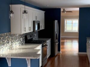 Kitchen with blue walls, stainless-steel appliances, and white cabinets.